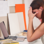 Stressed person working on computer | 4 Signs Your Business Has Employee Burnout | Safeguard